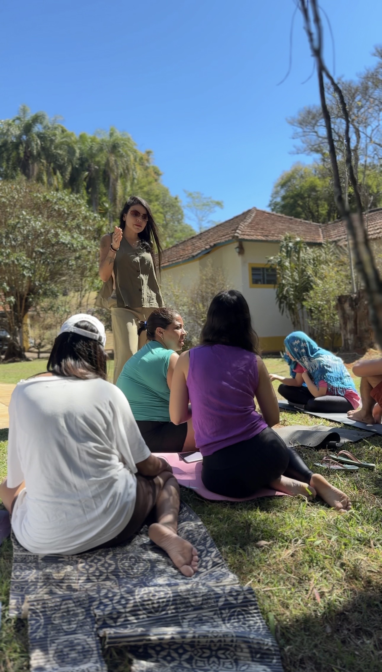 Ariadne facilitando sessão ao ar livre com grupo de mulheres